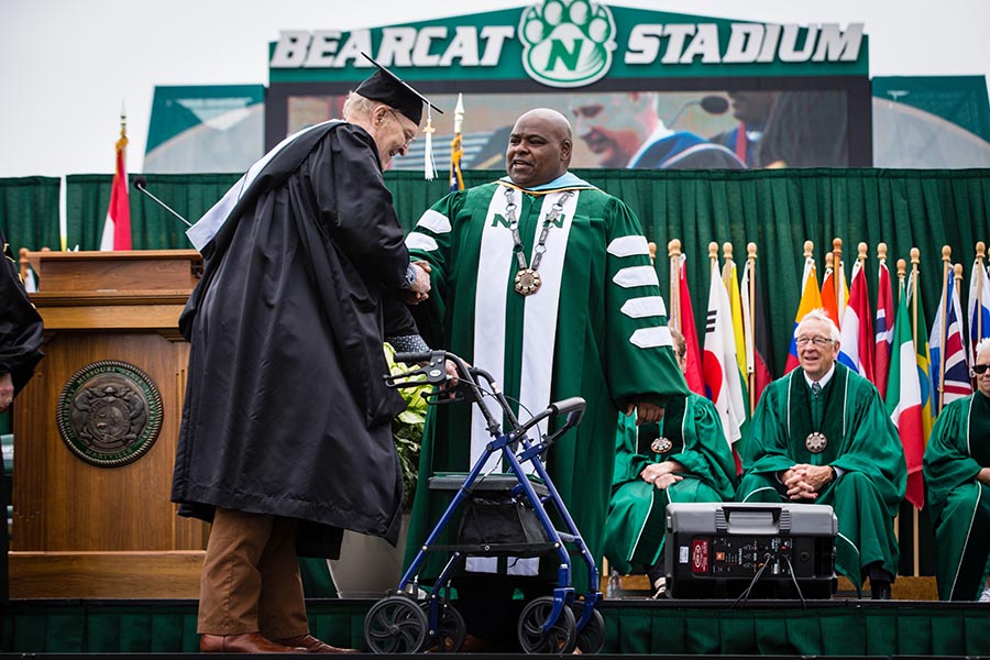 Dr. Clarence Green, who served as Northwest's interim president during the 2022-23 academic year, congratulated Gordon Hill as he crossed the commencement stage at Bearcat Stadium. 