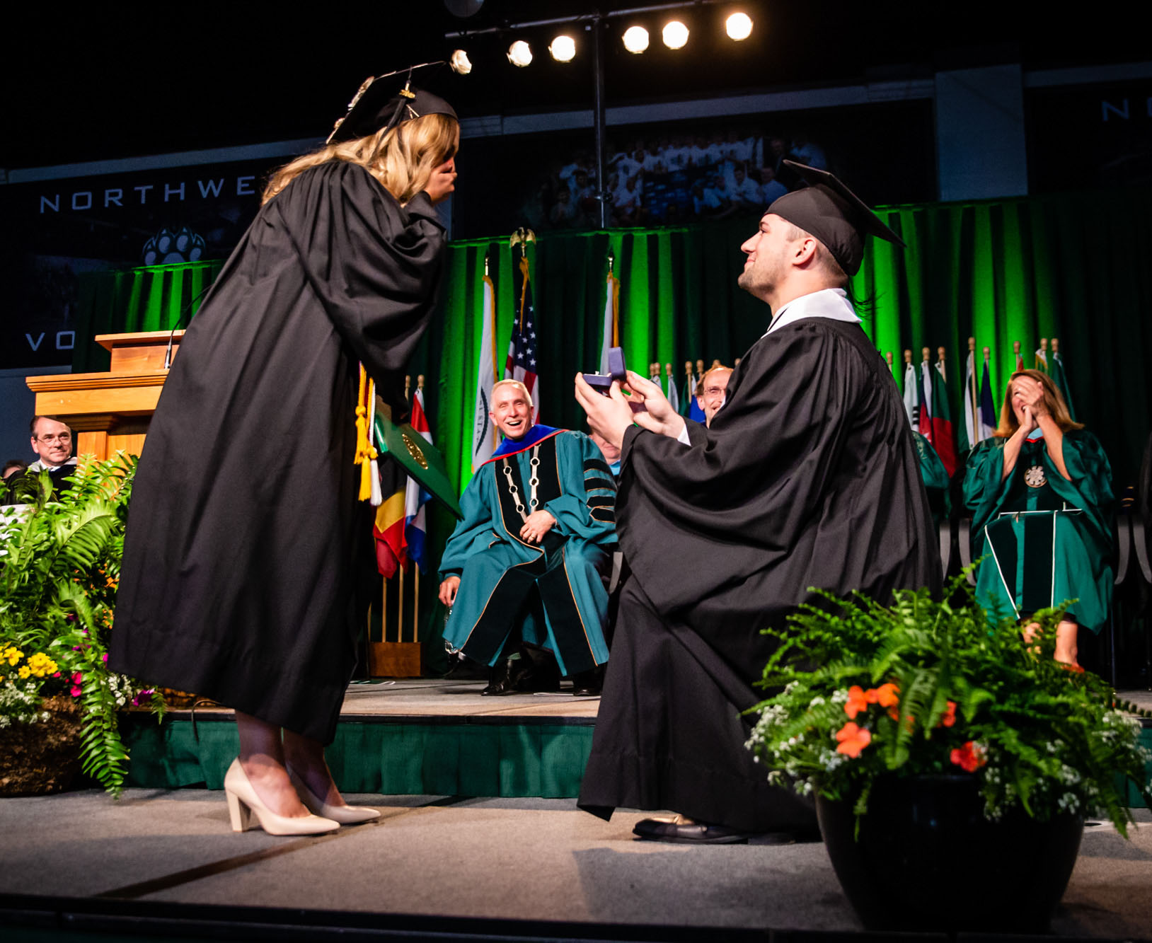 Northwest graduate Shane Miller proposes to classmate Sierra Horan during Friday's commencement ceremony.