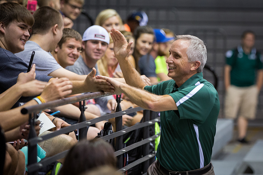 Whether giving high-fives at a convocation welcoming new students (above) or handing out donuts as students traveled across the campus to classes (below), Dr. J focused on helping students feel welcomed and valued at Northwest.
