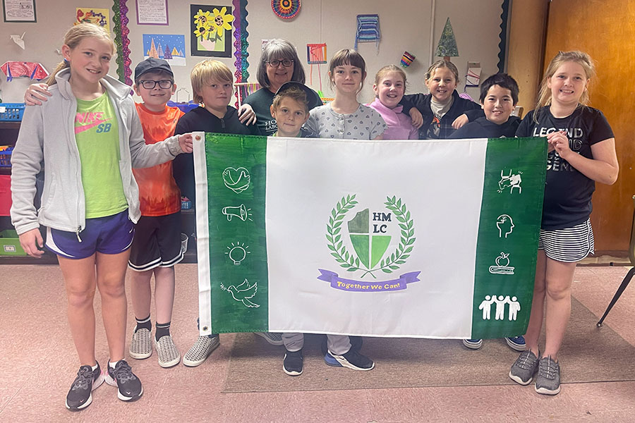 Horace Mann students in Sarah Winters’ fifth and sixth grade classroom, pictured with art teacher Lori Atkins, designed a flag to represent their school. (Submitted photo)