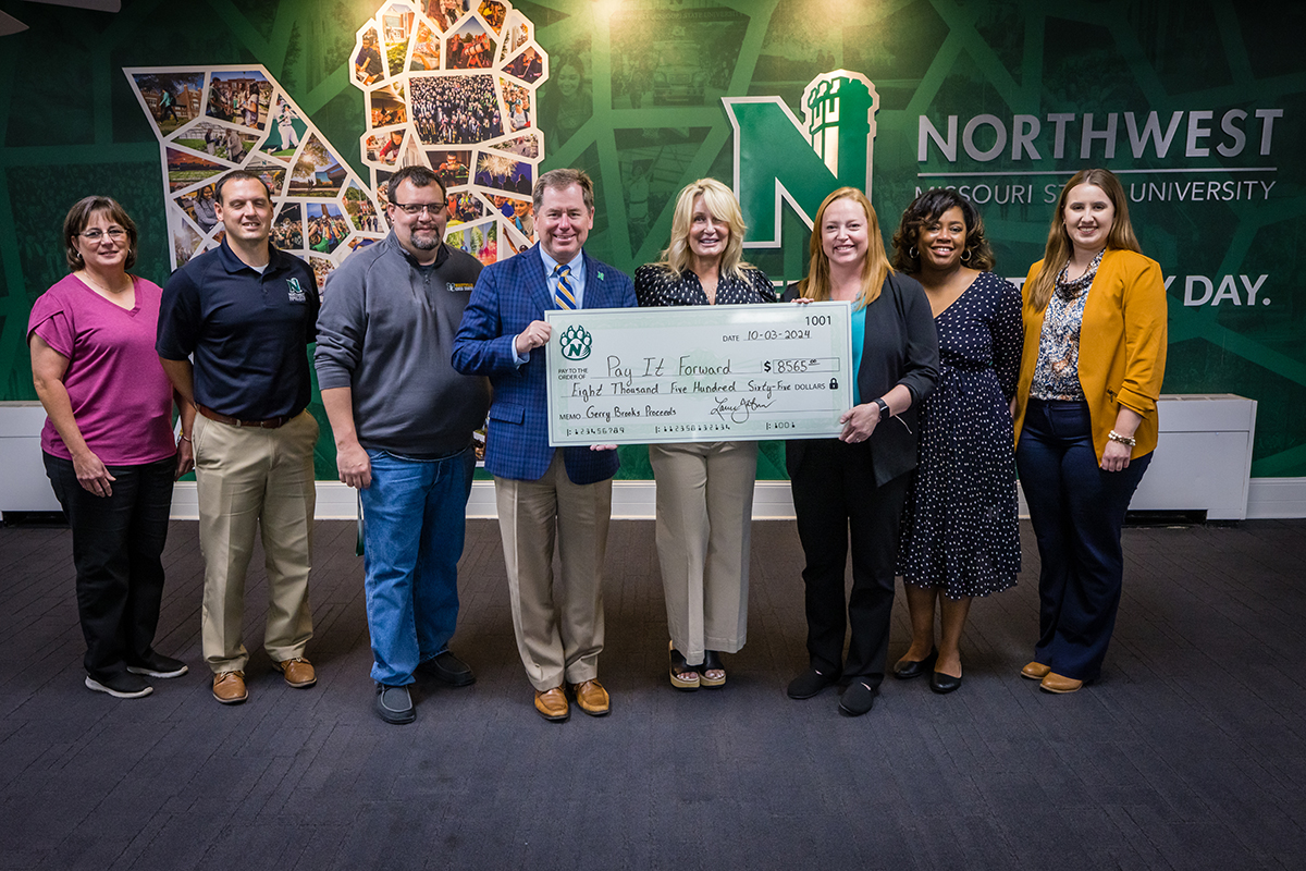 Representatives of Northwest’s Pay It Forward Fund committee joined the Tatums on Thursday to accept a donation to the fund. Pictured left to right are Janie Thacker,  Charles Mayfield, Anthony Christian, Dr. Lance Tatum, Jill Tatum, Selena Foreman, Dr. Shay Malone and Erika Lees. (Photo by Todd Weddle/Northwest Missouri State University)